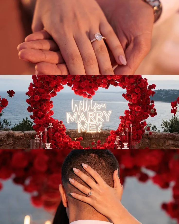 Red rose heart arch with a neon Will You Marry Me sign on a terrace overlooking the ocean