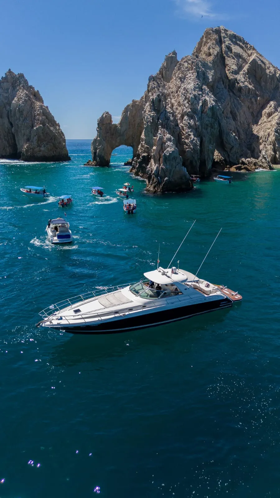 A private 65ft Sea Ray anchored on turquoise water beside El Arco at Lands End