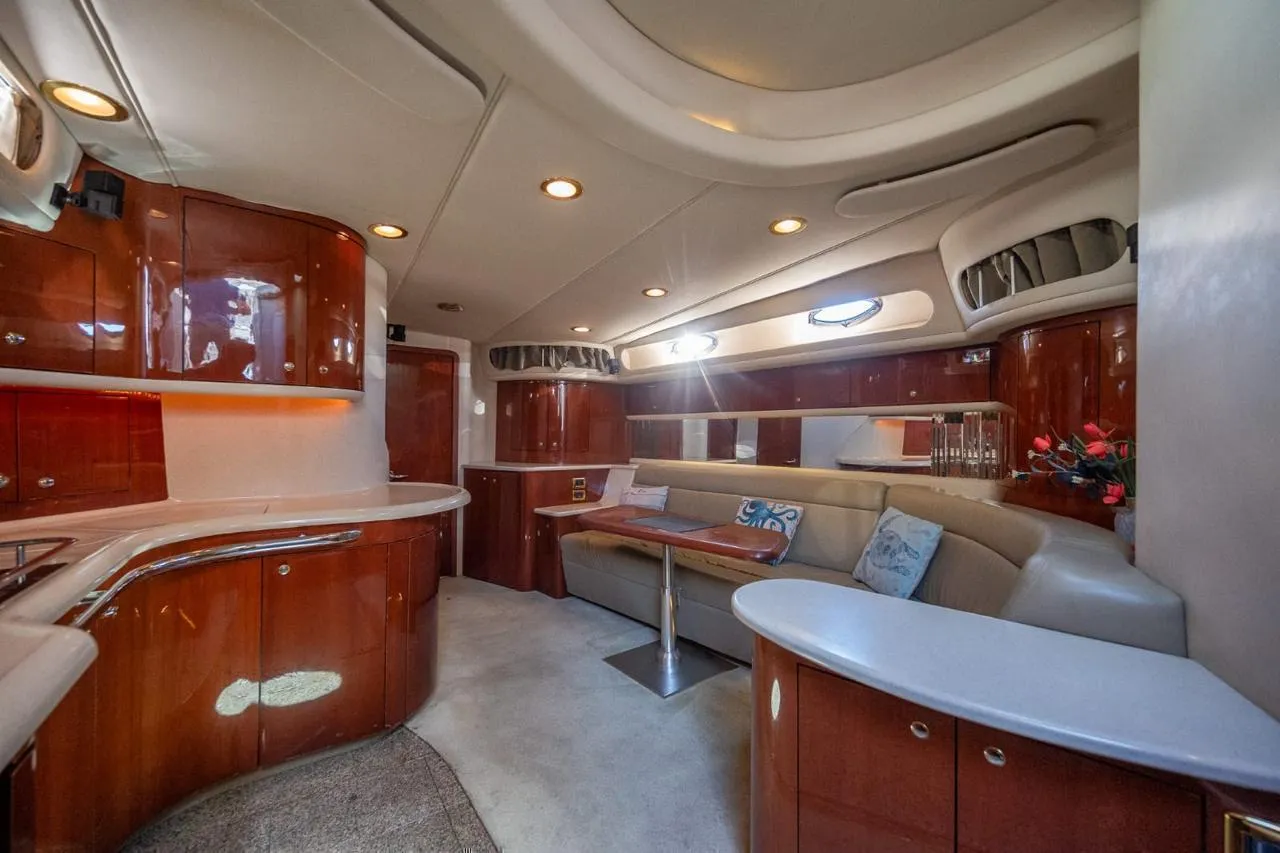 Salon interior of the yacht with seating, table and galley